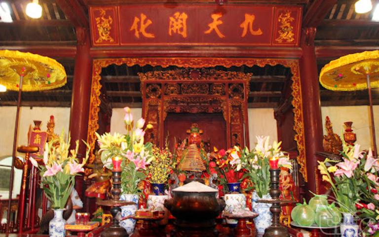 The altar area, which is elaborately decorated with statues, offering bowls, and incense burners, creating a rich tapestry of spiritual iconography.