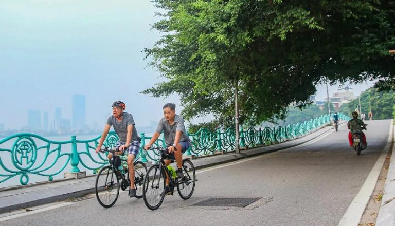 Cycling path around West Lake with lush greenery and scenic views.