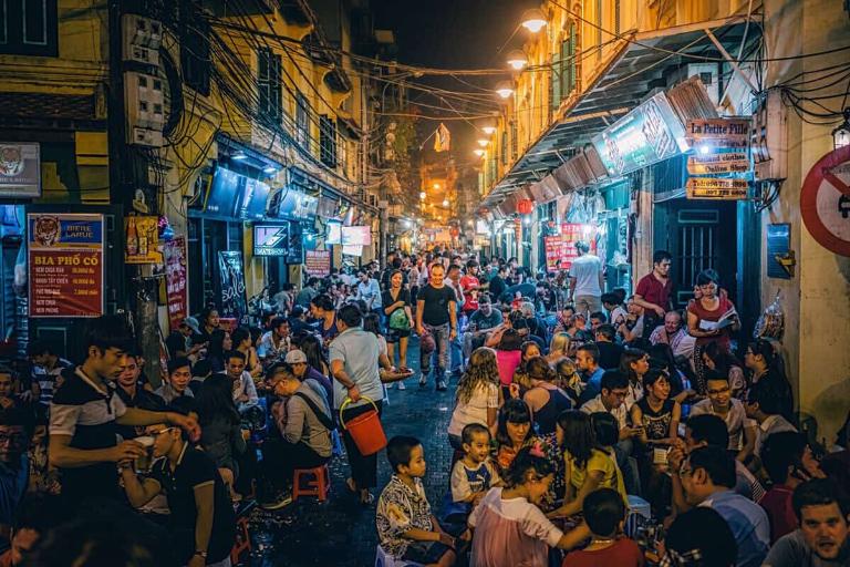 A bustling beer street in Hanoi with people enjoying drinks and socializing.