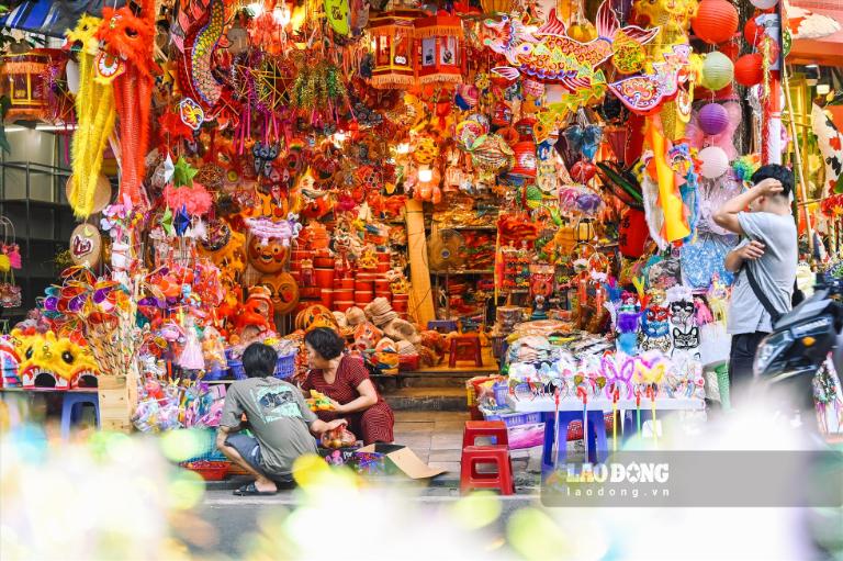 Market booths offering a broad range of paper products, decorative accents, and toys line the street.