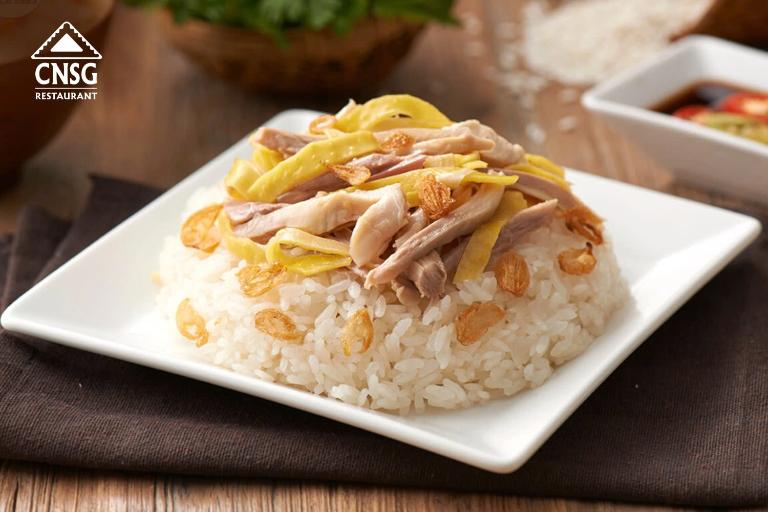 The shredded chicken is mixed with the rice, accompanied by sliced onions