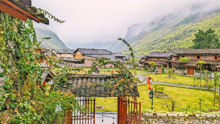 The tranquil village unfolds with lush greenery and fragrant blossoms.