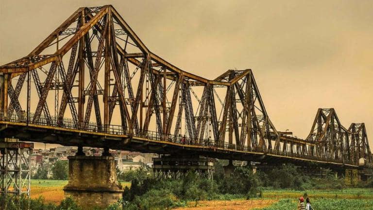 Walk Across Long Bien Bridge, one of the best things to do in Hanoi, offers stunning views of the Red River and the city.