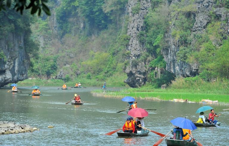 Go kayaking in Tam Coc to paddle through scenic waterways and limestone caves surrounded by lush greenery.