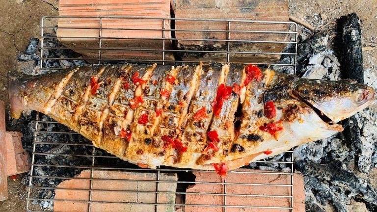 Local spices, like Doi seeds and Mac Khen, enhance the distinctive flavor of Grilled Stream Fish.