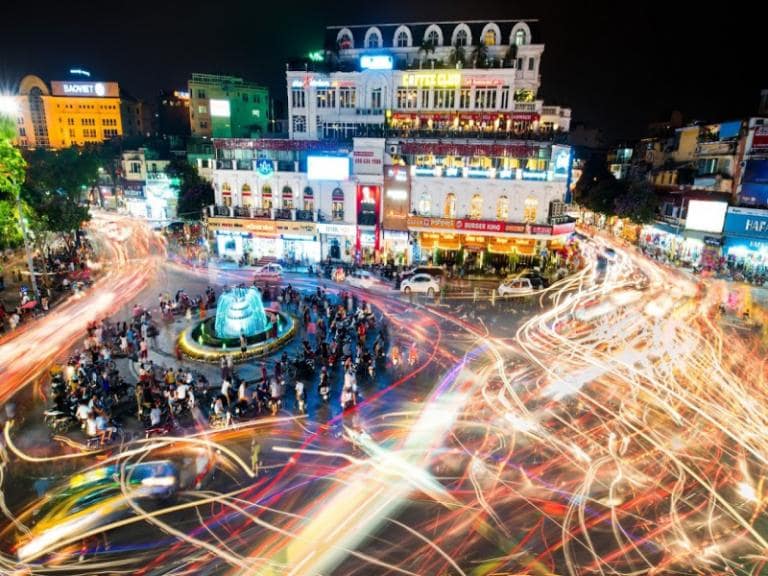 Hoan Kiem Lake at night: lively and calm, with cool air and locals strolling under soft lights.