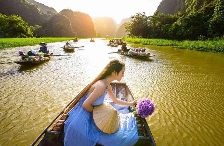 Tam Coc offers vibrant seasonal colors and majestic karsts, creating stunning backdrops for photography.