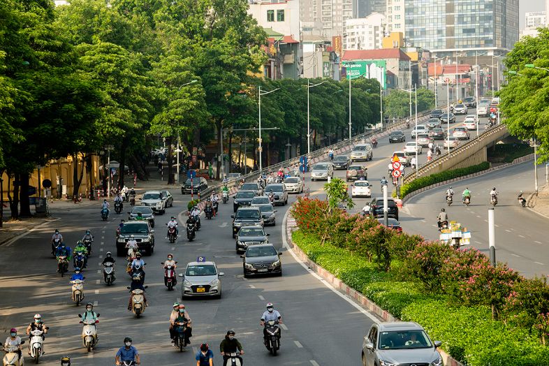 A bustling street in Vietnam filled with motorbikes and local traffic, capturing the energy of daily city life.