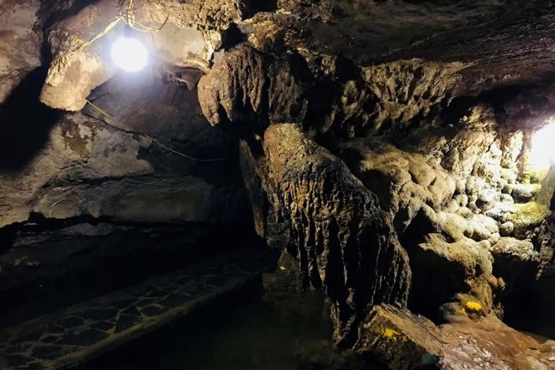 Interior of Mua Cave in Ninh Binh, Vietnam, showing limestone formations, rock pillars, and cave walls.