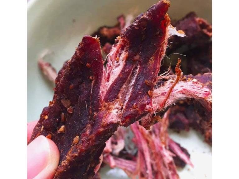 Dried buffalo meat is marinated, smoked, and known for its chewy, savory, and slightly sweet flavor.