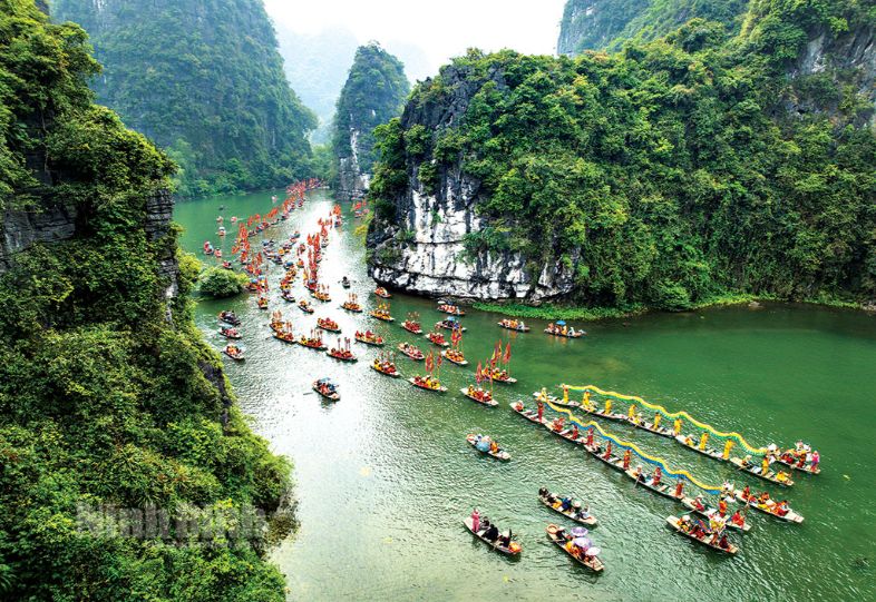 Scenic view of Ninh Bình, Vietnam, featuring limestone mountains, rivers, and lush greenery.