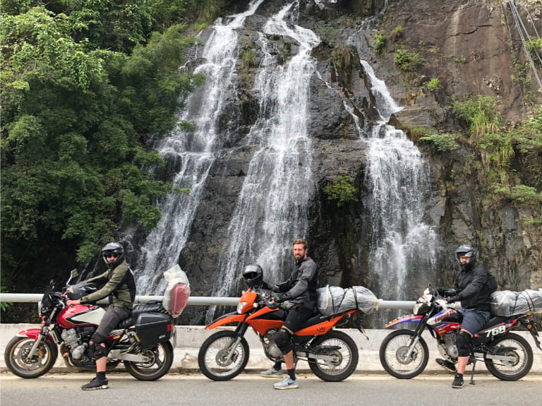A narrow mountain road on the Ha Giang Loop highlights sharp turns, steep drops, and the importance of riding slowly and staying alert.