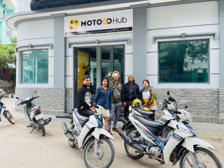 Tourists renting a motorbike at a rental spot in Vietnam.